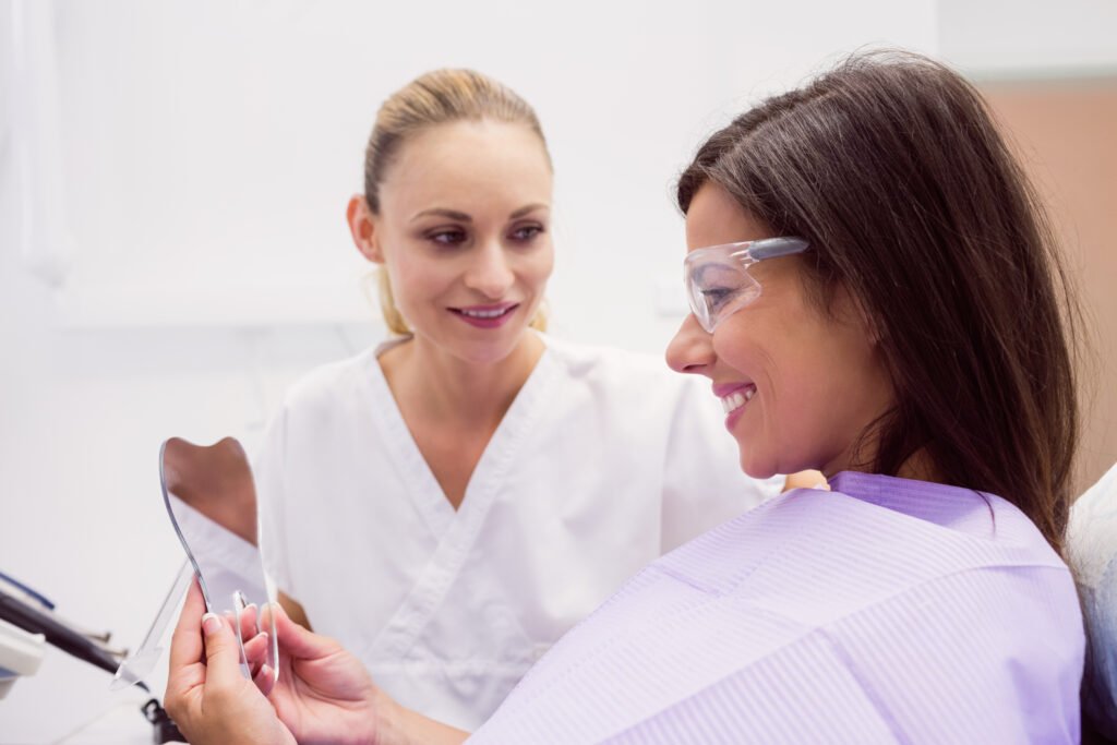 Female patient smiling while looking on the mirror in clinic