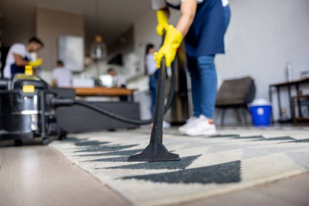 Close up on a professional cleaner vacuuming a carpet while working at an apartment housework concepts